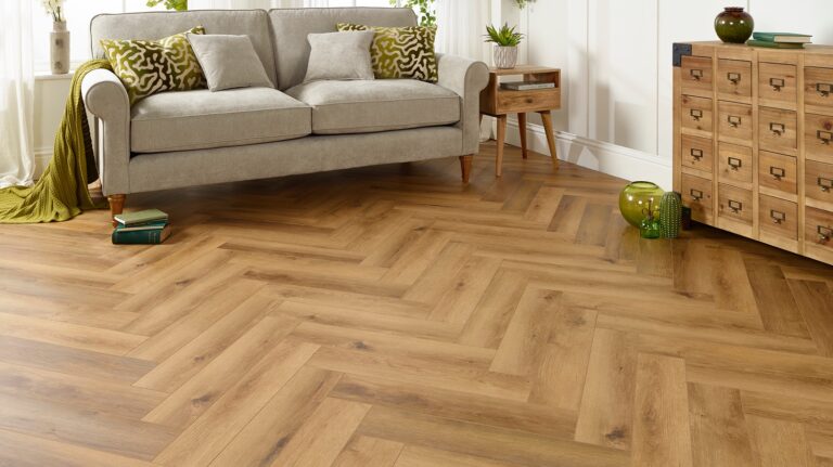 Living room featuring herringbone patterned flooring and a gray sofa
